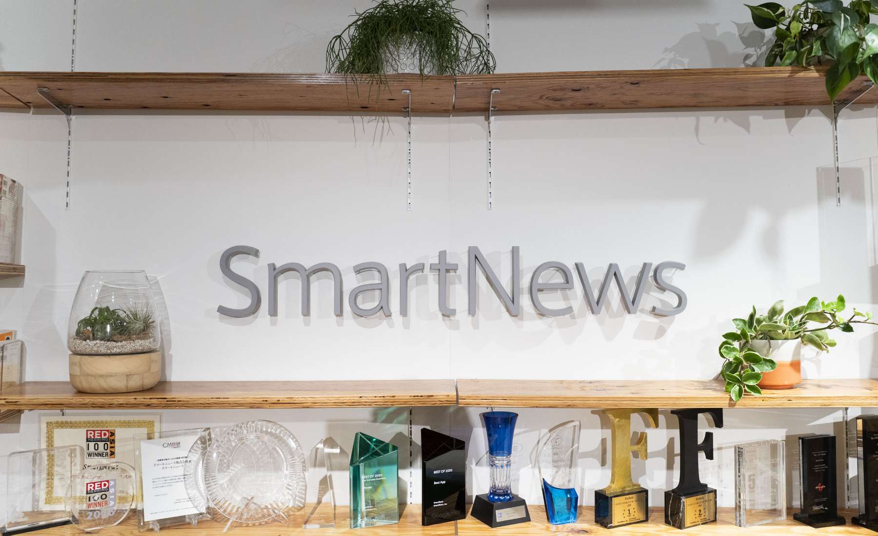 Smart News社の受付の様子。木製のカウンターや棚が設置され、明るくナチュラルな雰囲気。